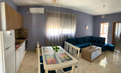 a kitchen and a living room with a blue couch at Guest House Tian in Durrës