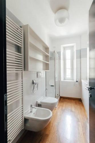 a white bathroom with a toilet and a sink at La casa di Isa in Lecco