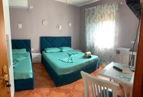 a bedroom with a blue bed and a table and a table at Guest House Tian in Durrës