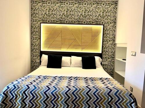 Schlafzimmer mit einem Bett mit einem großen Kopfteil in der Unterkunft Hotel Royal Suite Santander in Santander
