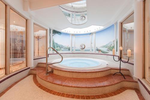 W pokoju z oknami znajduje się duża łazienka z wanną z hydromasażem. w obiekcie Hotel Dornauhof w mieście Finkenberg