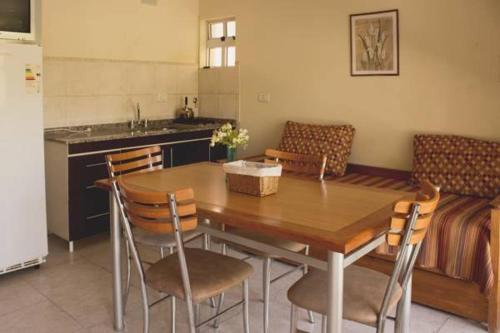 a kitchen with a wooden table and chairs in a kitchen at Los Arboles in Villa Urquiza