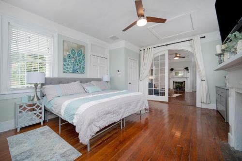 a white bedroom with a bed and a ceiling fan at Beautiful Historic Downtown Charleston Home in Charleston
