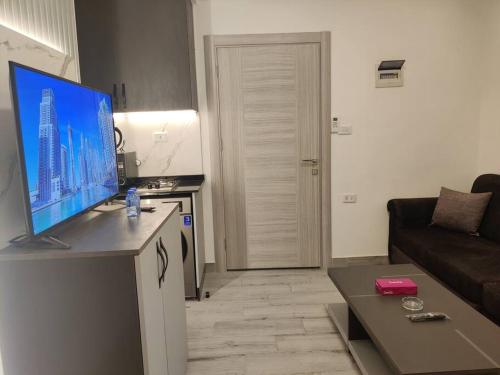 salon z telewizorem z płaskim ekranem na ladzie w obiekcie 46m luxury room near downtown and all services w mieście Amman
