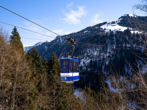 a blue and white cable car on a mountain at Ferienhaus Türtscher 1 in Sonntag