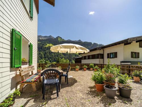 a patio with a table and chairs and an umbrella at Ferienhaus Türtscher 1 in Sonntag