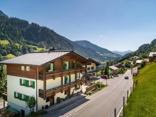 a house on a hill next to a road at Ferienhaus Türtscher 1 in Sonntag