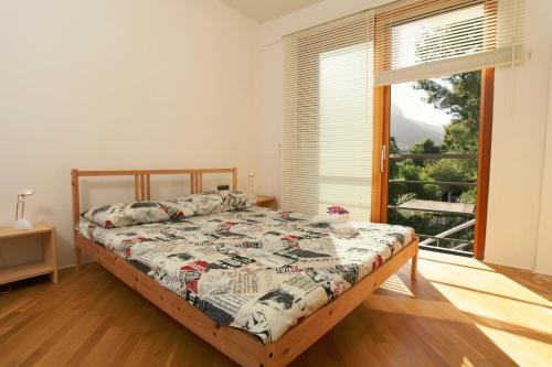 a bedroom with a bed and a large window at Pizzo Cane House camera con bagno e piscina in Altavilla Milicia