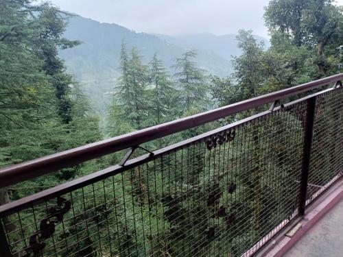 a balcony with a view of a forest at Peace holiday homestay in Chail