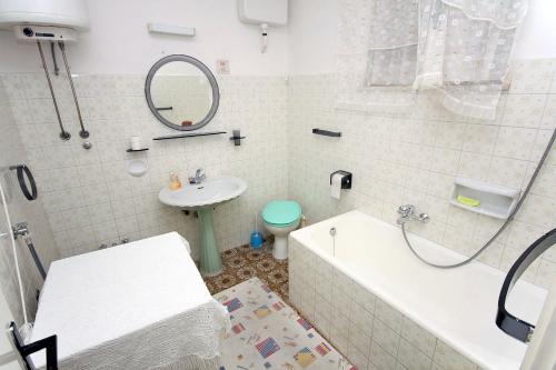 a bathroom with a tub and a sink and a toilet at Rooms with WiFi Dubrovnik - 4693 in Dubrovnik