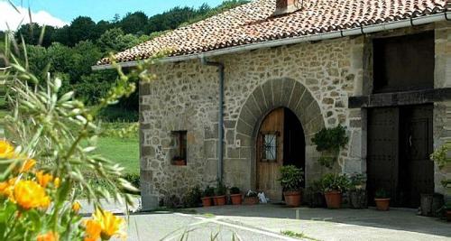 um edifício de pedra com um arco e uma porta em Hermoso Caserío Navarra. (Madoz) 