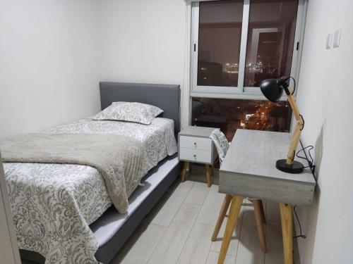 a bedroom with a bed and a desk and a window at Epiqe Manuel Olguin 600 in Lima