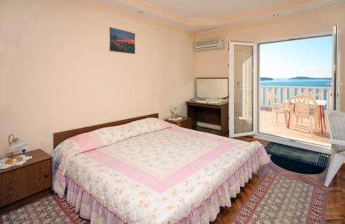 a bedroom with a bed and a balcony at Apartments with a swimming pool Soline, Dubrovnik - 4762 in Mlini