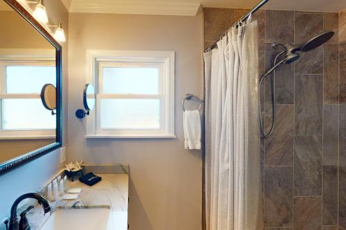 a bathroom with a shower and a sink and a mirror at Portola Oasis in Monterey
