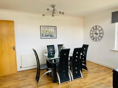 uma sala de jantar com uma mesa preta e cadeiras pretas em The OVO Hydro Penthouse With Free Parking em Glasgow