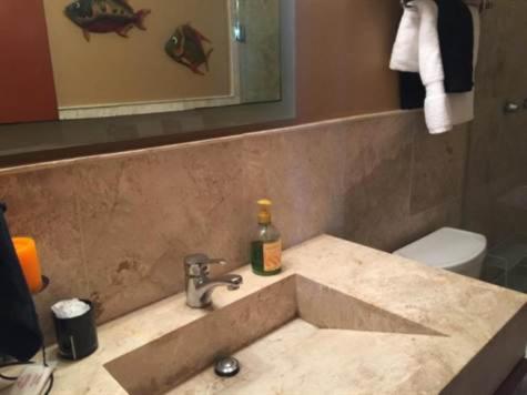 a bathroom with a sink and a toilet and a mirror at Tiara Sands 302 in Mazatlán