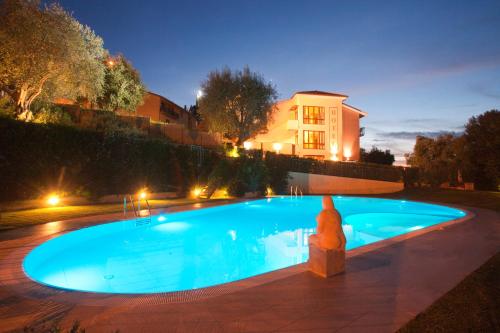 a large blue swimming pool in a yard at night at Valle Del Buttero in Capalbio