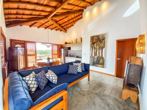 a living room with a blue couch and a kitchen at Oceà Privilegi - Taipu de Fora in Barra Grande