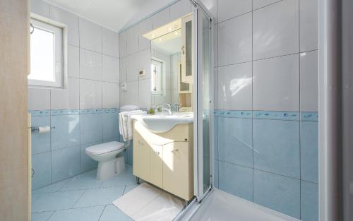 La salle de bains est pourvue de toilettes, d'un lavabo et d'une douche. dans l'établissement Apartment Basanija 3402f, à Savudrija