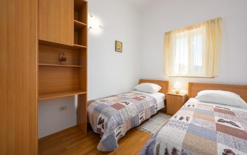 - une chambre avec 2 lits et une fenêtre dans l'établissement Apartment Basanija 3402f, à Savudrija