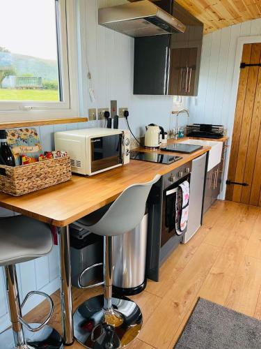 a kitchen with a counter with a microwave on it at Bespoke luxury huts with hot tubs. Located in the black mountains. in Llanveynoe