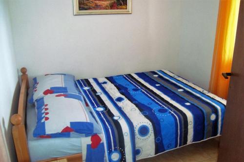 a bed with blue and white sheets in a bedroom at Seaside secluded apartments Cove Skozanje, Hvar - 4624 in Gdinj