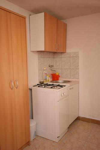 a kitchen with a white stove top oven next to a toilet at Seaside secluded apartments Cove Skozanje, Hvar - 4624 in Gdinj