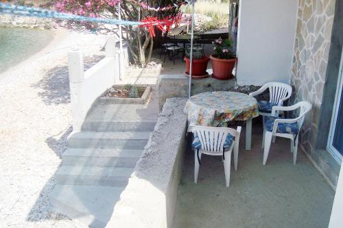 a table and chairs sitting outside of a house at Seaside secluded apartments Cove Skozanje, Hvar - 4624 in Gdinj