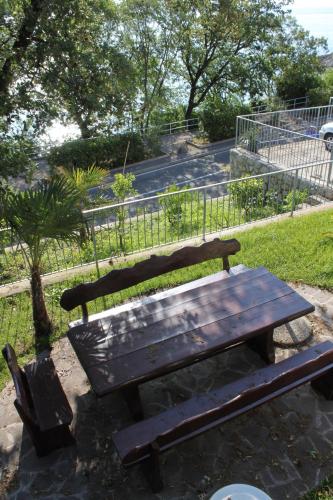 a wooden bench and a picnic table in a park at Apartment Medveja 3430b in Medveja