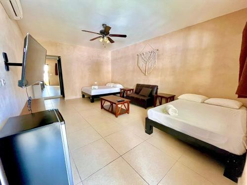 a room with two beds and a flat screen tv at We playa Hotel-Hostel in Playa del Carmen