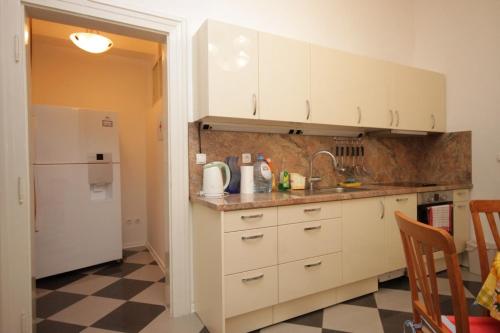 a kitchen with white cabinets and a refrigerator at Apartments with a parking space Opatija - 3436 in Opatija