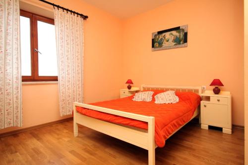 Veprinac的住宿－Family friendly house with a swimming pool Veprinac, Opatija - 3447，一间卧室配有一张带橙色墙壁和窗户的床