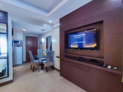 ein Hotelzimmer mit einem TV und einem Esszimmer in der Unterkunft TWO PALMTREE VILLAS NEWPORT BOULEVARD NEAR NAIA 3 PASAY CITY in Manila
