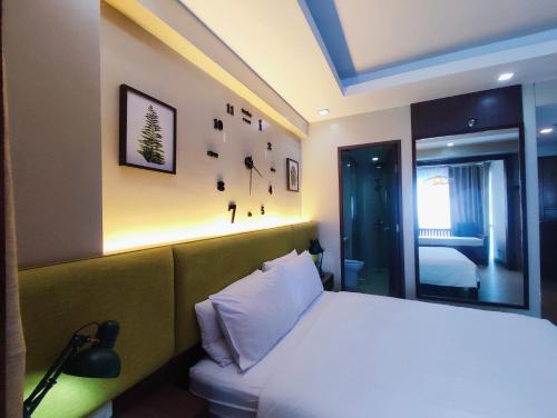a bedroom with a white bed with a lamp and a window at TWO PALMTREE VILLAS NEWPORT BOULEVARD NEAR NAIA 3 PASAY CITY in Manila