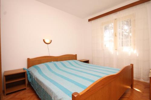 a bedroom with a bed with a blue and white stripes at Apartments by the sea Susica, Ugljan - 3462 in Ugljan