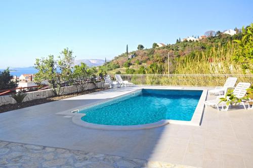 - une piscine avec 2 chaises longues dans l'établissement Apartments and rooms with a swimming pool Cavtat, Dubrovnik - 4733, à Cavtat