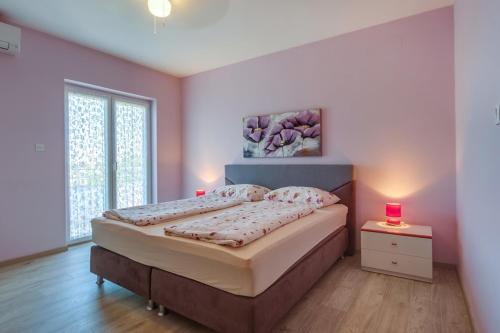 a bedroom with a bed with two red candles on it at Double Room Mali Losinj 3445h in Mali Lošinj