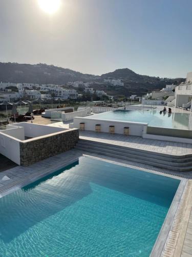 a large swimming pool with blue water on a building at The George Hotel Mykonos in Platis Yialos Mykonos