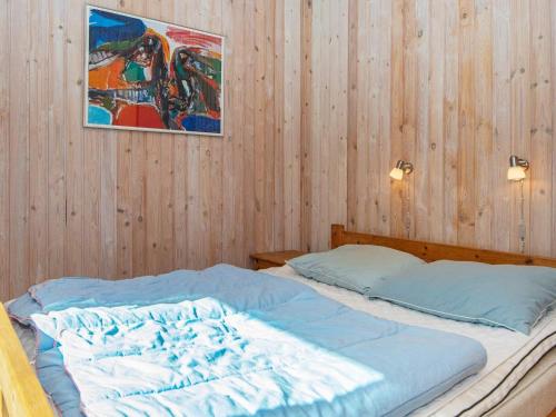 a bedroom with a bed with a picture on the wall at Holiday Home Strandskadevej in Ørsted