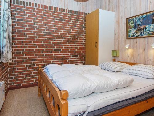 a bed in a room with a brick wall at 6 person holiday home in Ørsted-By Traum in Ørsted