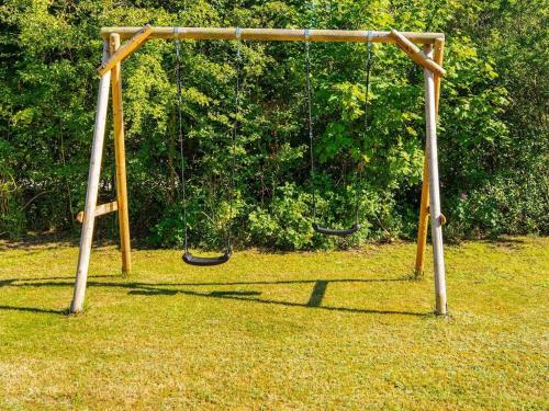 an empty swing set in a field of grass at 6 person holiday home in Ørsted-By Traum in Ørsted