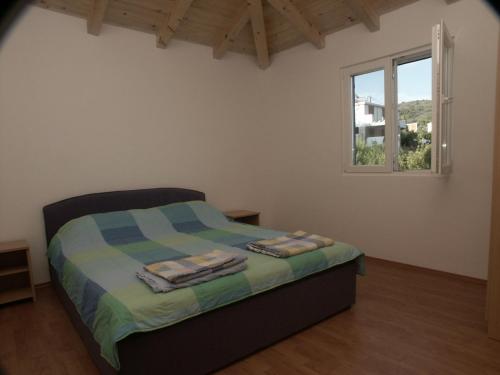 Schlafzimmer mit einem Bett und einem Fenster in der Unterkunft Apartments by the sea Milna, Vis - 3036 in Vis