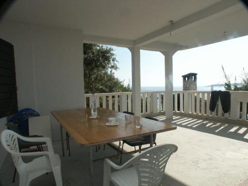 einen Tisch und Stühle auf einer Veranda mit Meerblick in der Unterkunft Apartments by the sea Milna, Vis - 3036 in Vis