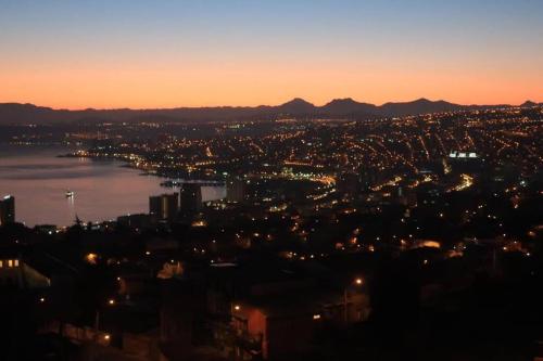a view of a city at night with the water at Departamento Cerro Alegre 113 in Valparaíso