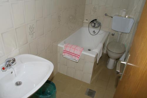 Apartments by the sea Baska Voda, Makarska - 2724 في باسكا فودا: حمام أبيض مع حوض ومرحاض