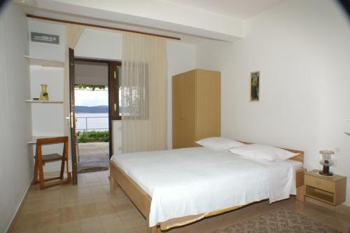 1 dormitorio con cama y vistas al océano en Apartments by the sea Pisak, Omis - 2750, en Pisak