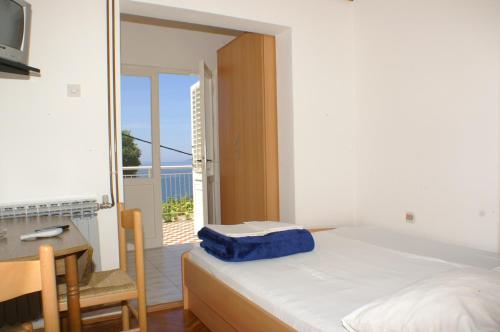 Schlafzimmer mit einem Bett, einem Schreibtisch und einem Balkon in der Unterkunft Apartments by the sea Podaca, Makarska - 3037 in Podaca