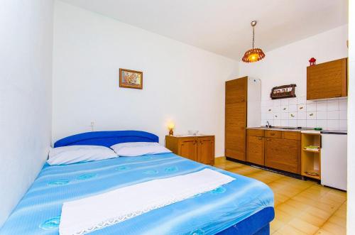Cet appartement comprend une chambre avec un lit bleu et une cuisine. dans l'établissement Studio Pisak 2802a, à Pisak