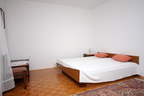 een slaapkamer met een bed met oranje kussens erop bij Apartments by the sea Podaca, Makarska - 2695 in Podaca