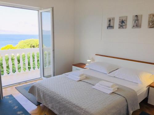 sypialnia z łóżkiem i dużym oknem w obiekcie Apartments and rooms by the sea Zivogosce - Porat, Makarska - 2733 w mieście Živogošće